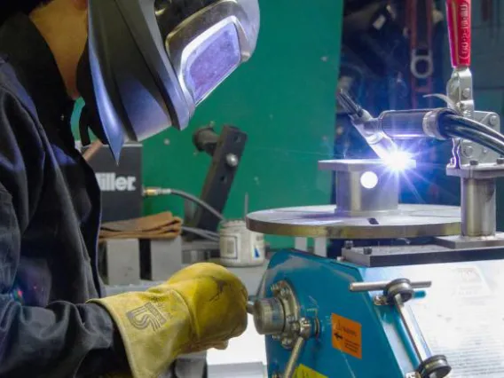 A person with safety equipment is welding